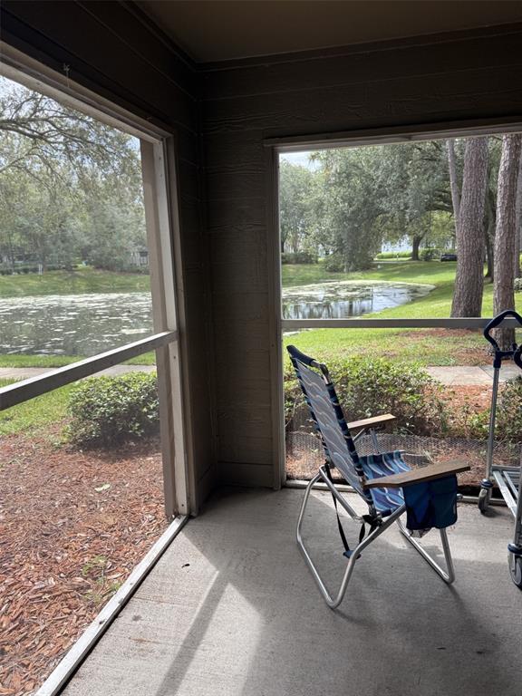 A kitchen with light-colored cabinets, a dishwasher, and a view into the living area — 5136 PARK CENTRAL DRIVE UNIT 215, ORLANDO, FL