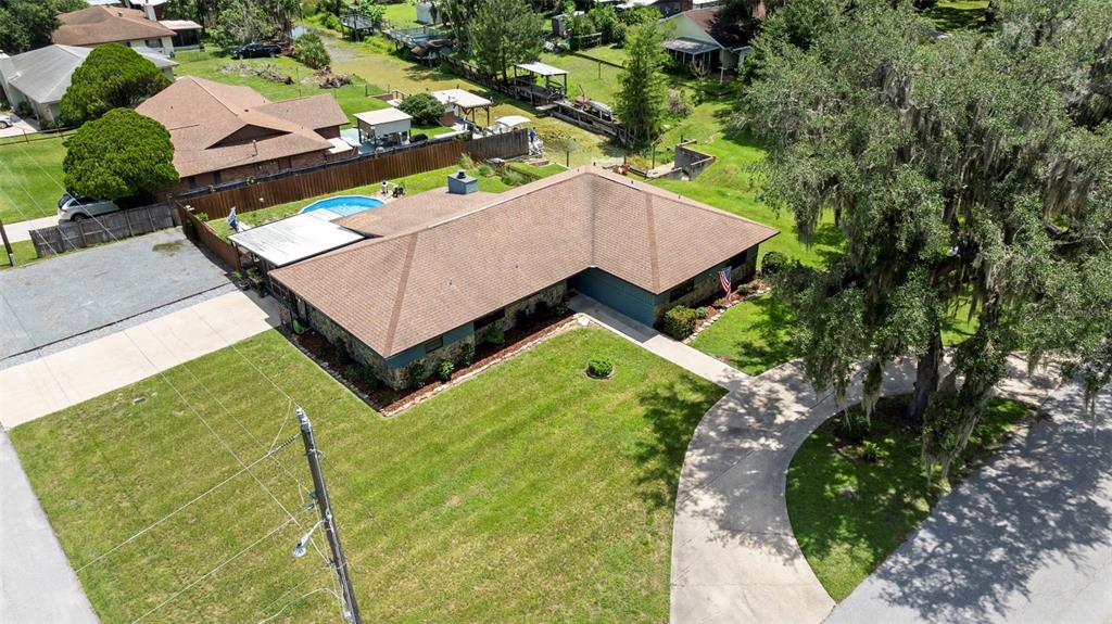 An aerial view shows a single-story house with a brown roof, lawn, and driveway — 1351 CR 482N, LAKE PANASOFFKEE, FL