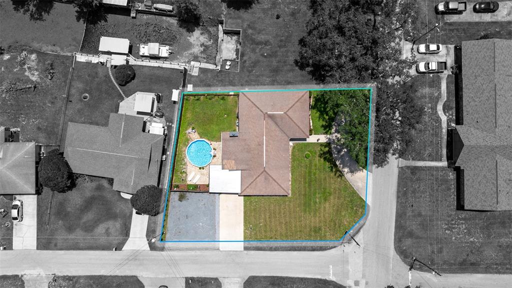 An aerial view shows a house with a brown roof, a pool, and a fenced yard — 1351 CR 482N, LAKE PANASOFFKEE, FL