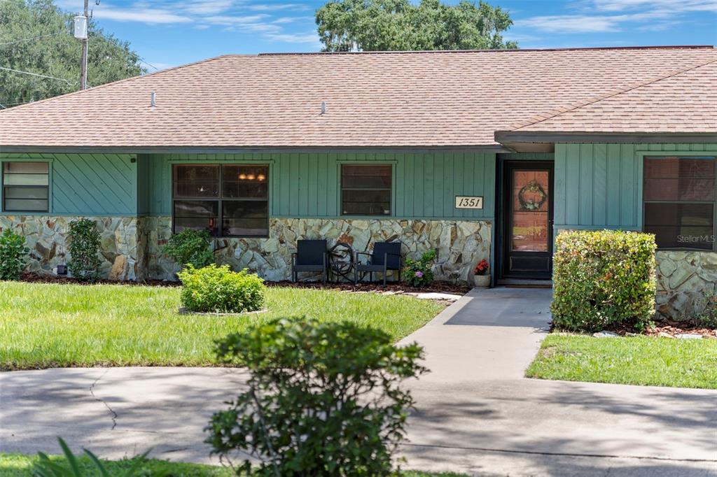 A single-story house features a stone facade, teal vertical siding, and a brown shingled roof — 1351 CR 482N, LAKE PANASOFFKEE, FL