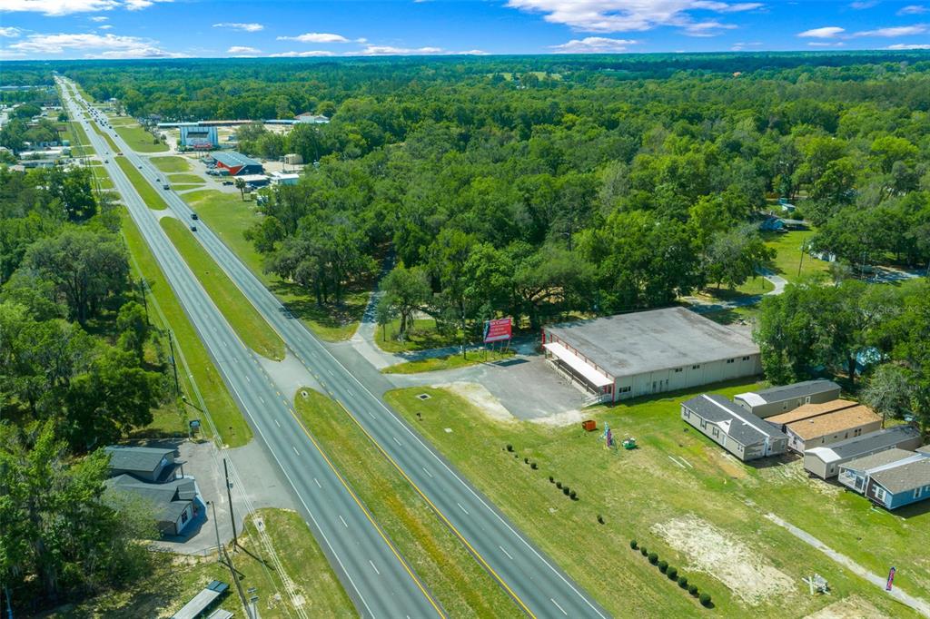 An aerial view shows a commercial building and adjacent houses along a multi-lane highway — 4450 S PINE AVENUE, OCALA, FL