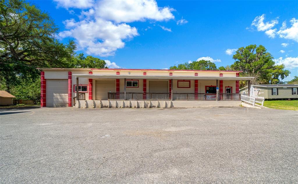 A commercial building with a loading dock, roll-up doors, and a covered porch — 4450 S PINE AVENUE, OCALA, FL