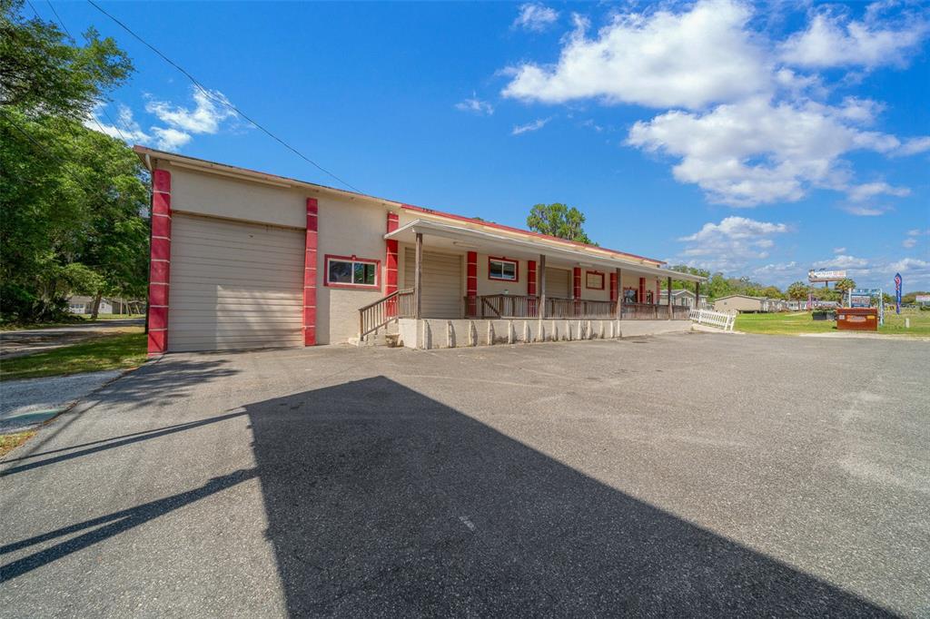 A commercial building features a large garage door, a loading dock, and a covered porch — 4450 S PINE AVENUE, OCALA, FL