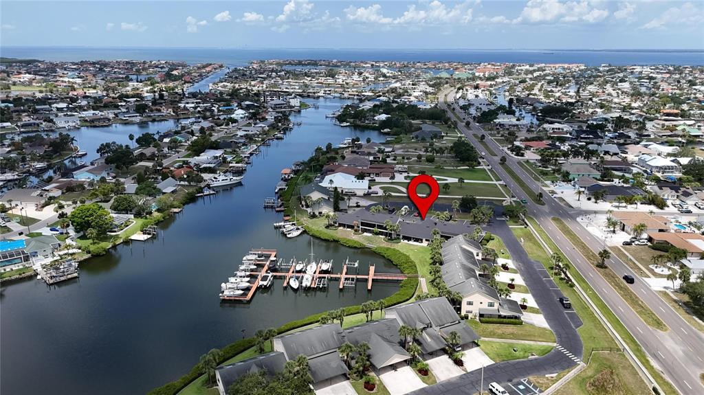 An aerial view shows a waterfront residential complex with a private boat dock and marina — 644 YARDARM DRIVE UNIT 22, APOLLO BEACH, FL