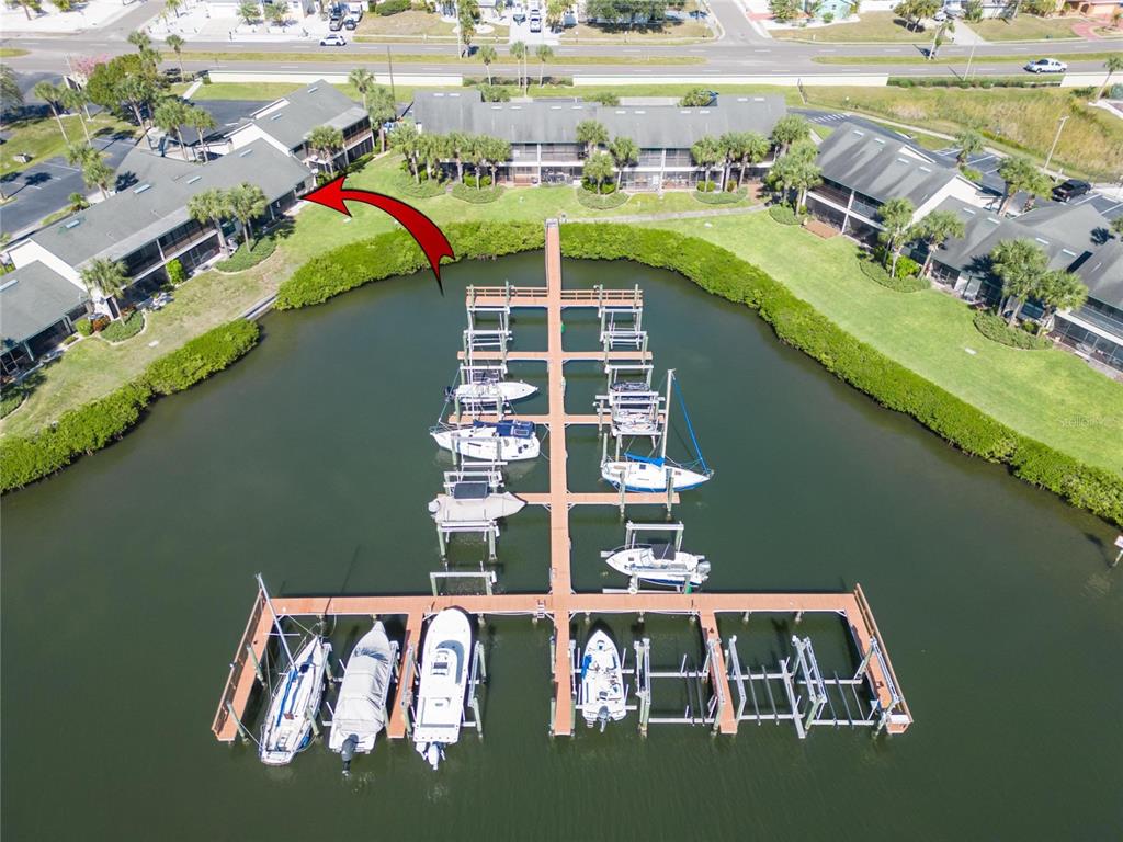 An aerial view shows a boat dock with multiple slips extending from a waterfront residential complex — 644 YARDARM DRIVE UNIT 22, APOLLO BEACH, FL