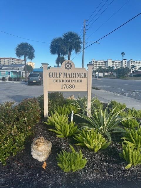 A wall-mounted coat rack with decorative signs and a vertical shelving unit on a wall — 17580 GULF BOULEVARD UNIT 403, REDINGTON SHORES, FL