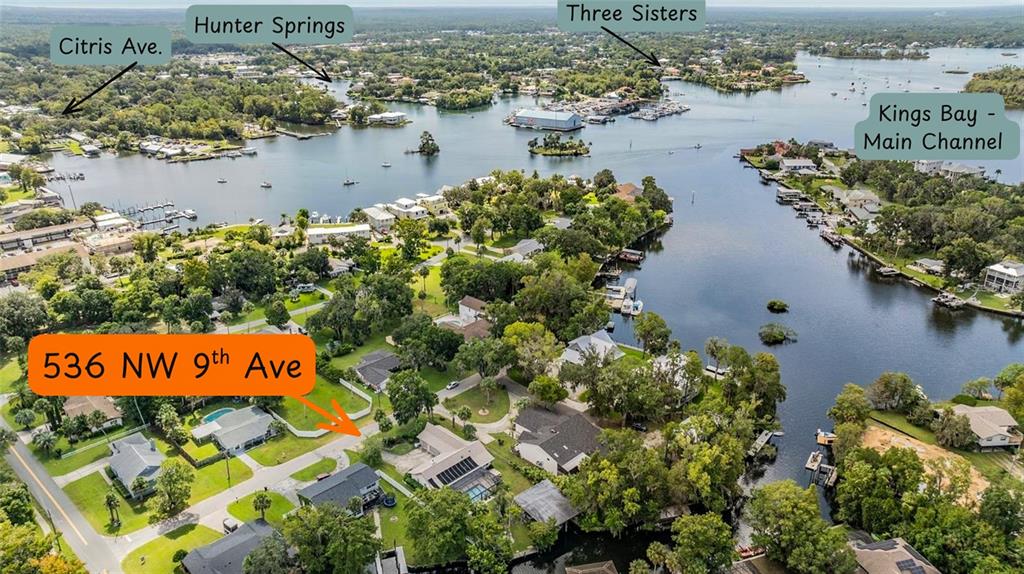 This aerial view shows a residential neighborhood situated along the waterfront of Kings Bay — 536 NW 9TH AVENUE, CRYSTAL RIVER, FL