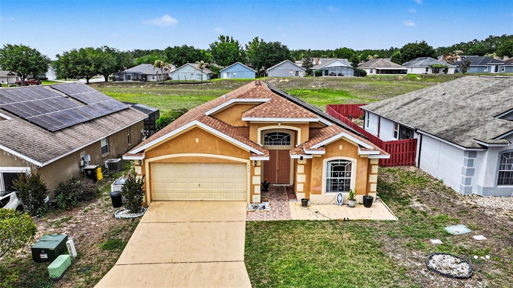 An aerial view shows a single-story tan house with a two-car garage and shingled roof — 732 GLENCO DRIVE, DAVENPORT, FL