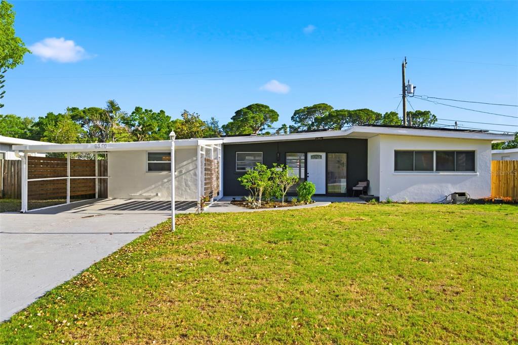 A single-story house with a white exterior, a dark accent wall, and an attached carport — 6350 HAMPTON DRIVE N, ST PETERSBURG, FL