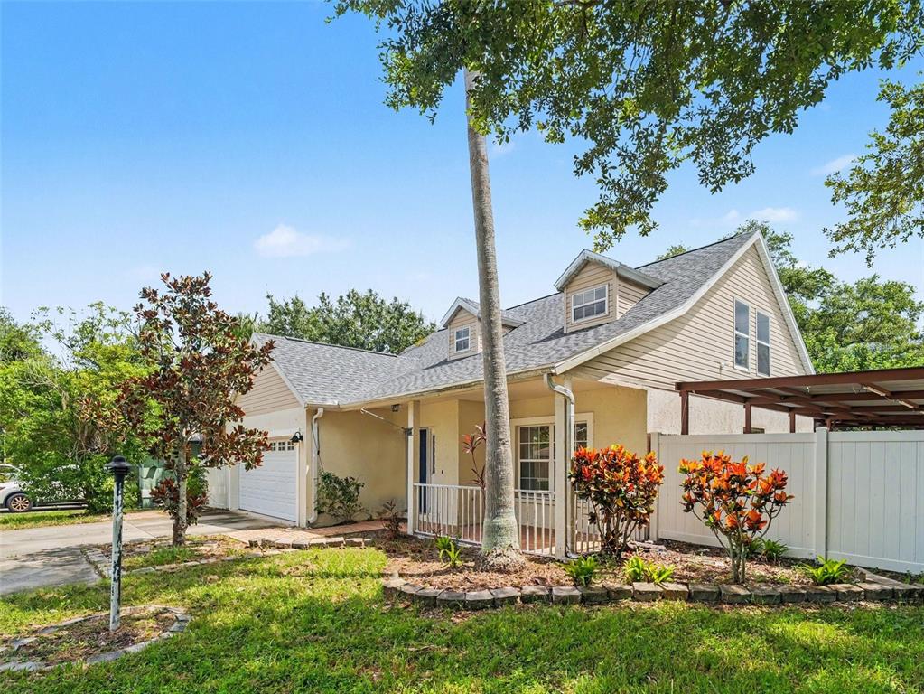 A beige house with a gabled roof, dormer windows, a front porch, and a carport — 3715 E 31ST STREET, BRADENTON, FL