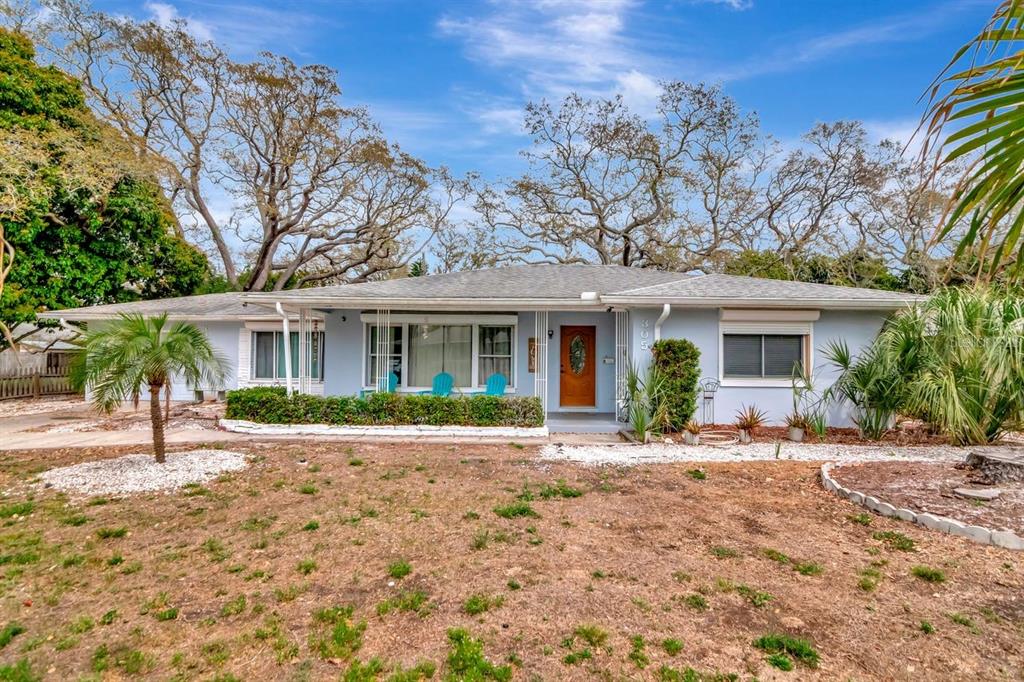 A single-story light blue house with a brown front door and a dry front yard — 305 BAKER AVENUE, CLEARWATER, FL