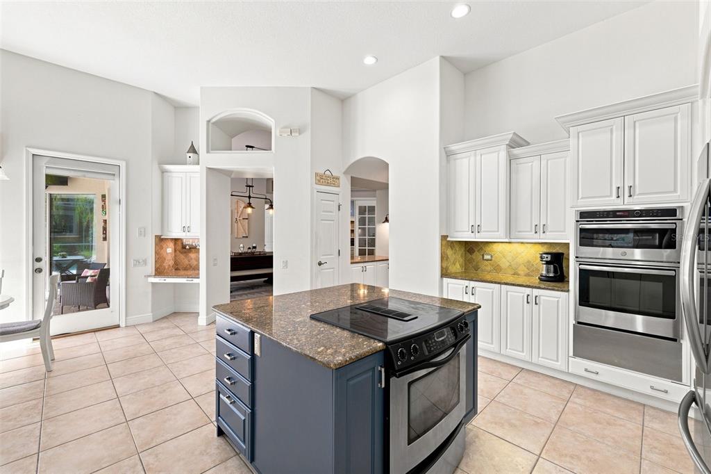 A kitchen with white cabinets, a blue island, stainless steel appliances, and tile flooring — 5091 JASMINE WAY, PALM HARBOR, FL