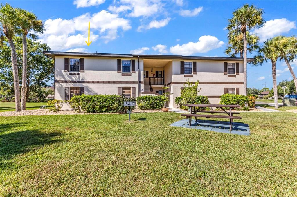 A two-story apartment building with a picnic table on the lawn in front — 19505 QUESADA AVENUE UNIT T203, PORT CHARLOTTE, FL