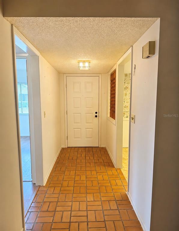 A living and dining room with wood-look flooring, a round table, and a sofa — 2531 ROYAL PINES CIRCLE UNIT 23E, CLEARWATER, FL