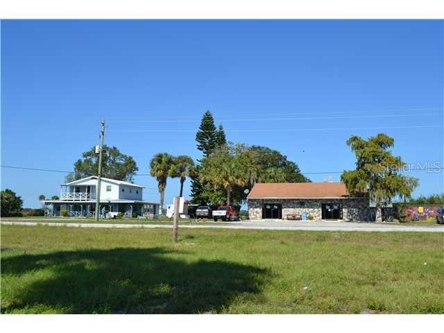 A two-story house and a single-story stone building stand near a grassy field — 6275 US-441 HIGHWAY SE, OKEECHOBEE, FL