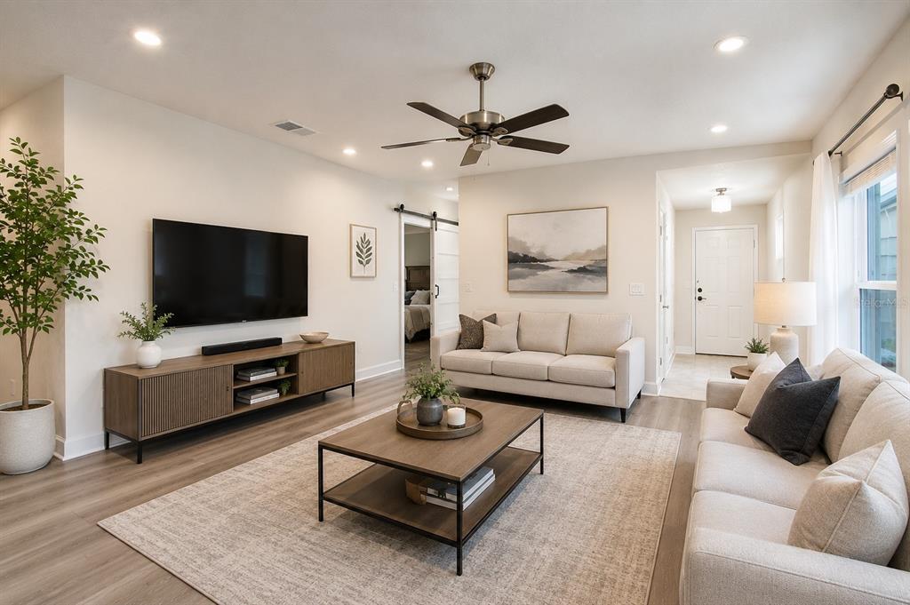 A screened-in porch with two folding chairs overlooking a grassy yard and a pond — 3675 SAGEFIELD DRIVE, HARMONY, FL