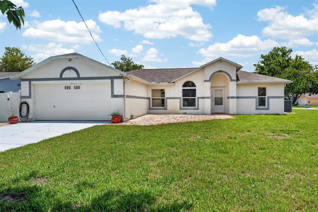 A single-story house with a white stucco exterior, a two-car garage, and a front patio — 20 LAKE MEADOW WAY, ORMOND BEACH, FL
