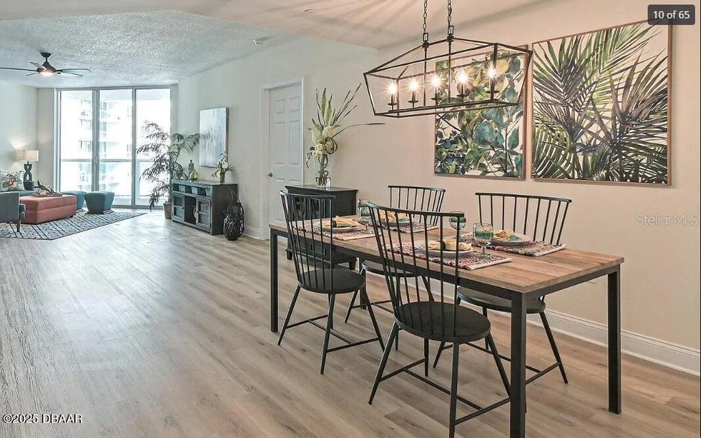 A dining area with a wooden table and black chairs sits beside a living room — 231 RIVERSIDE DRIVE UNIT 2206, HOLLY HILL, FL