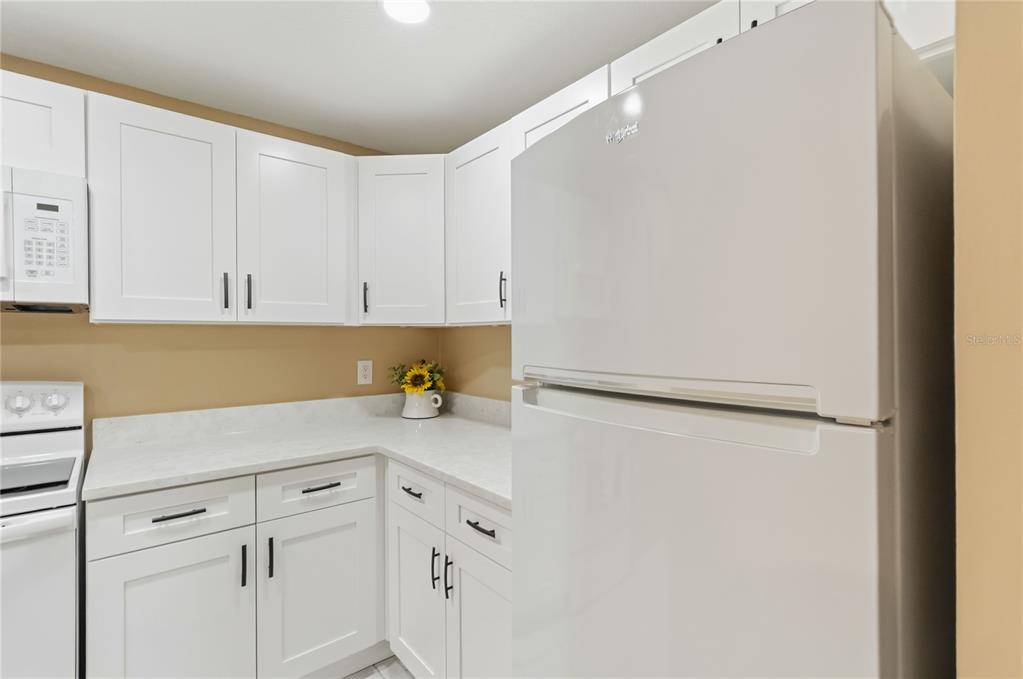 An empty room with light wood-look flooring, beige walls, a ceiling fan, and sliding glass doors — 164 PERIMETER DRIVE UNIT 4A, DELTONA, FL