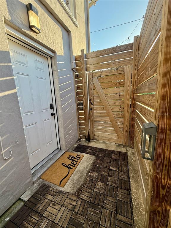 An exterior entryway features a white door, a hello doormat, and a wooden privacy fence — 3528 5TH AVENUE N, ST PETERSBURG, FL