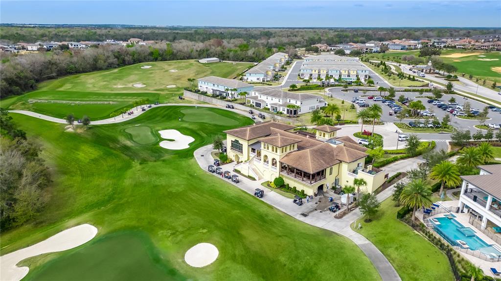 An aerial view shows a golf course clubhouse, parking lot, and adjacent residential buildings — 7857 SPECTRUM DRIVE, REUNION, FL