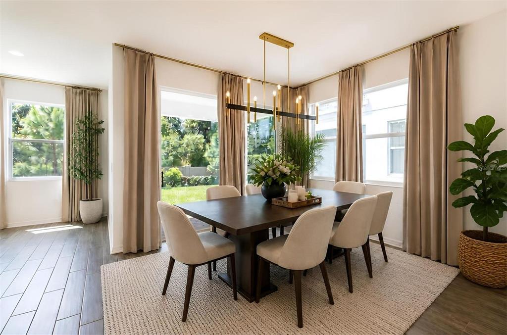 A dining room features a dark wood table, six upholstered chairs, and a modern gold chandelier — 5675 GREEN ARROW PLACE, SANFORD, FL
