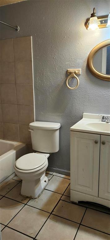 A bathroom featuring a white toilet, a vanity with a sink, and a tiled shower area — 9809 N JASMINE AVENUE UNIT B, TAMPA, FL