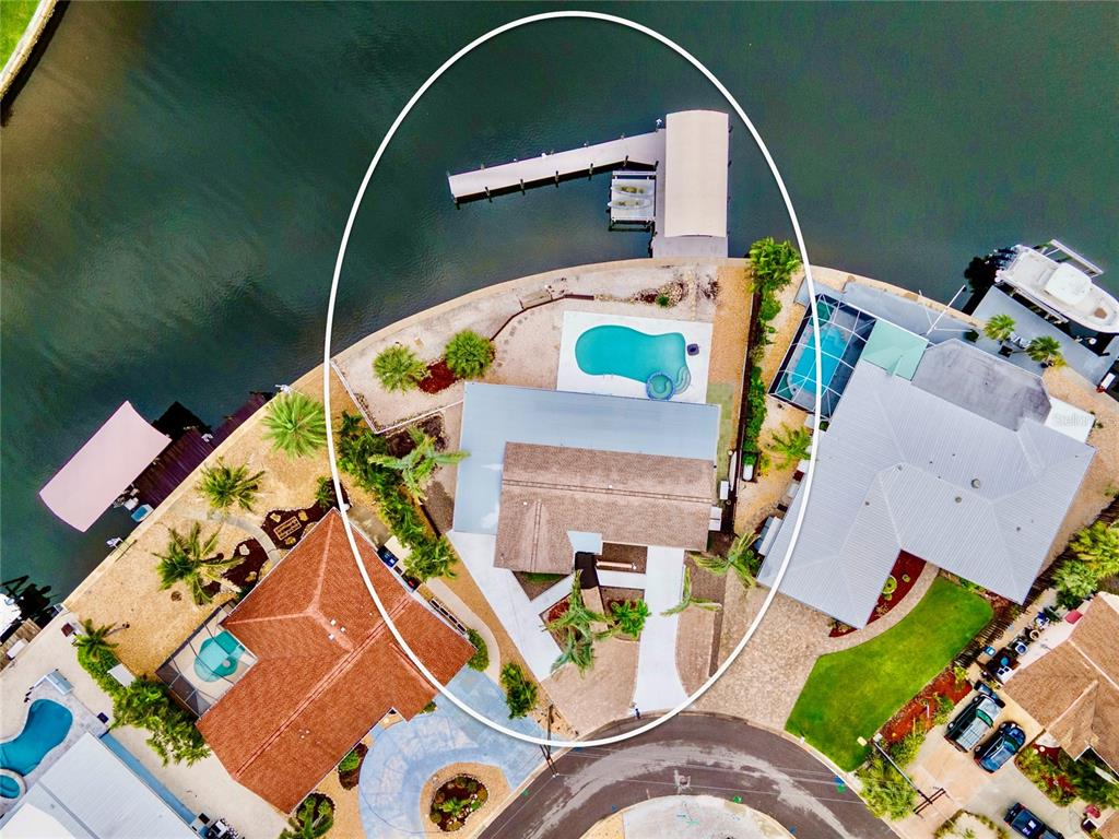 An aerial view shows a waterfront house with a swimming pool and a private boat dock — 4223 ROYAL PALM DRIVE, BRADENTON, FL