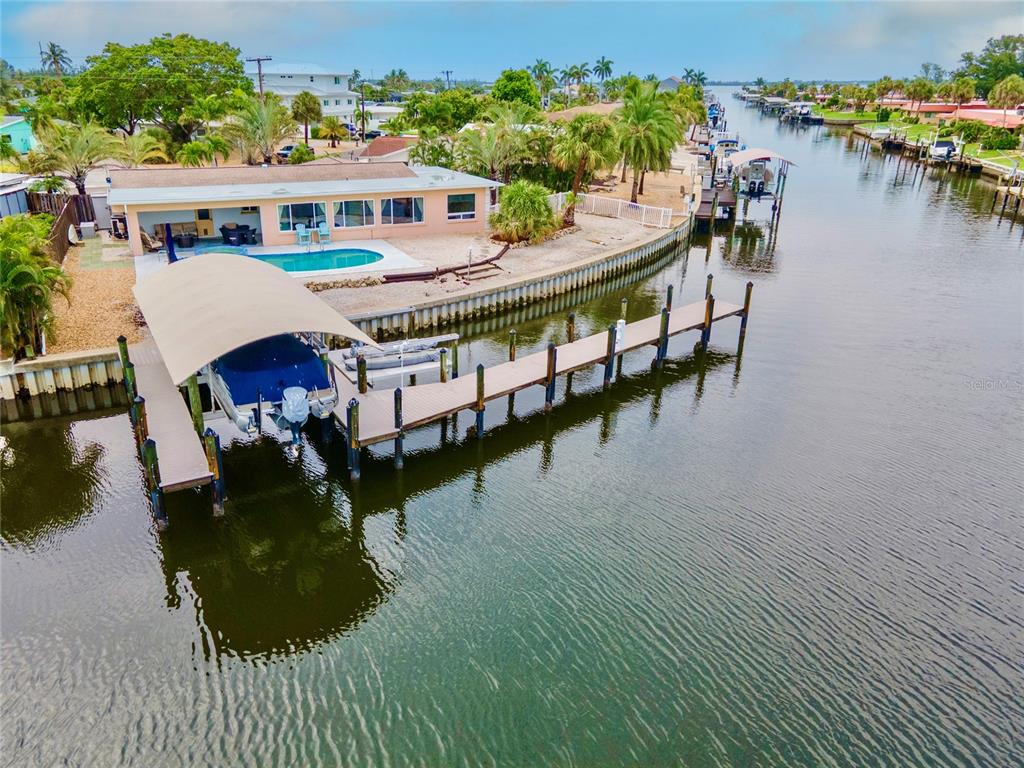 An aerial view shows a waterfront house with a swimming pool and a private boat dock — 4223 ROYAL PALM DRIVE, BRADENTON, FL