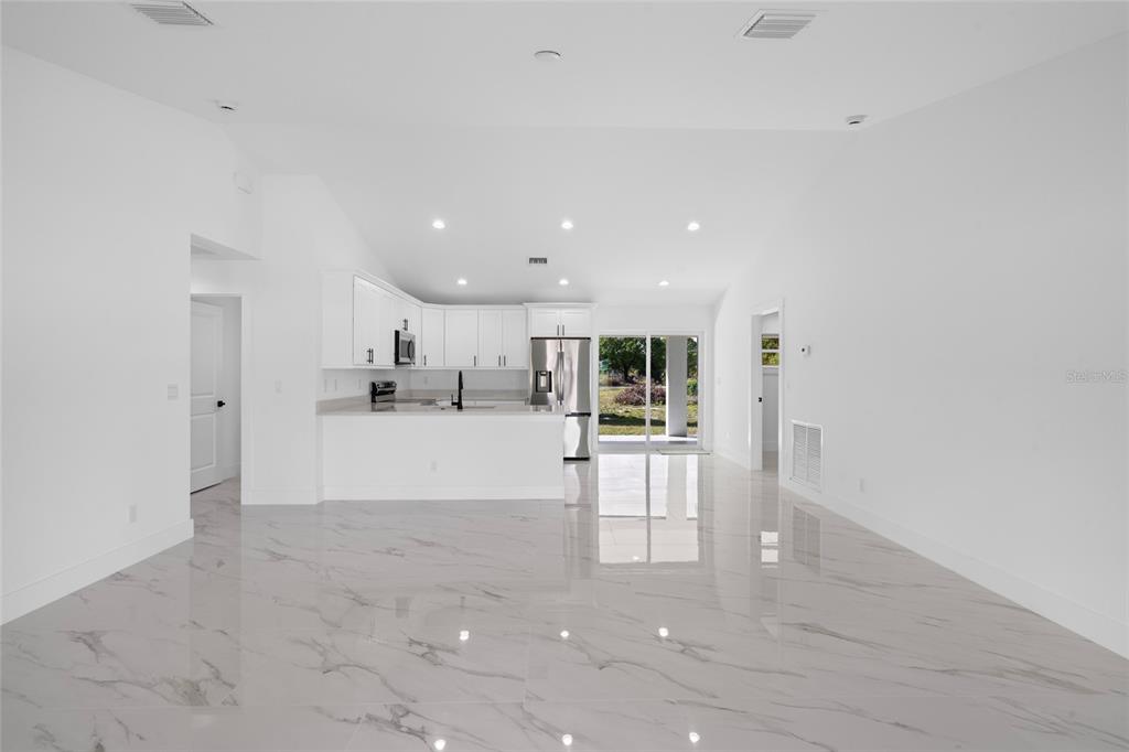 A white house with a dark roof and dormer windows sits behind a gravel driveway — 17932 NW 288TH STREET, OKEECHOBEE, FL