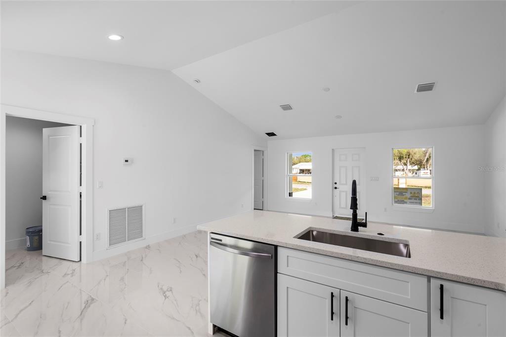 A white single-story house with a dark roof and two dormers sits on a lawn — 17932 NW 288TH STREET, OKEECHOBEE, FL