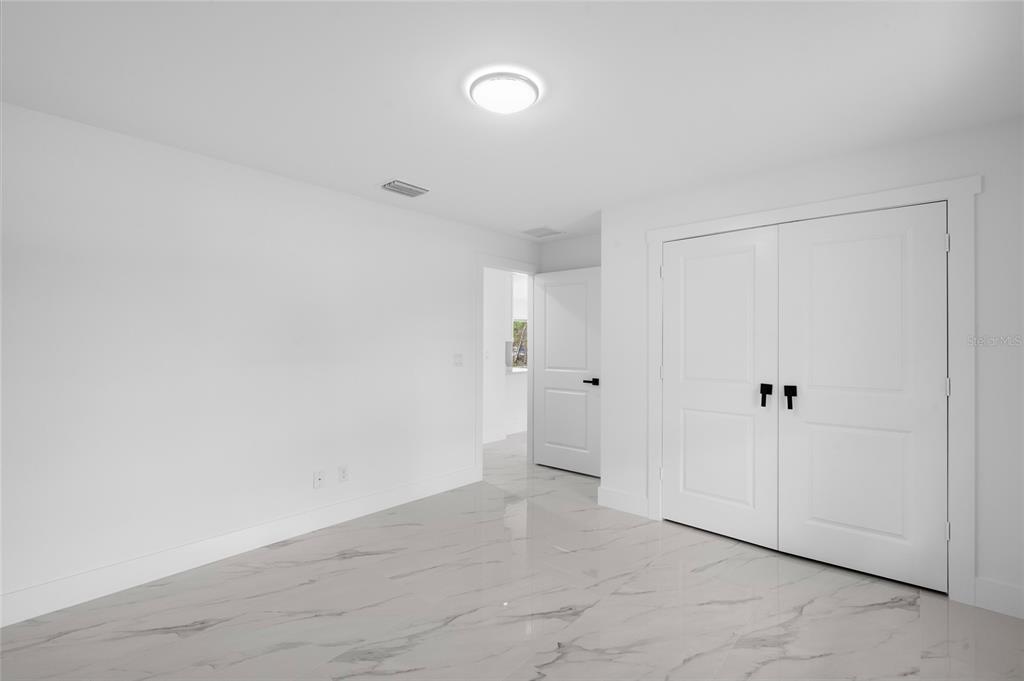 A white exterior wall features a central door flanked by two windows with black frames — 17932 NW 288TH STREET, OKEECHOBEE, FL