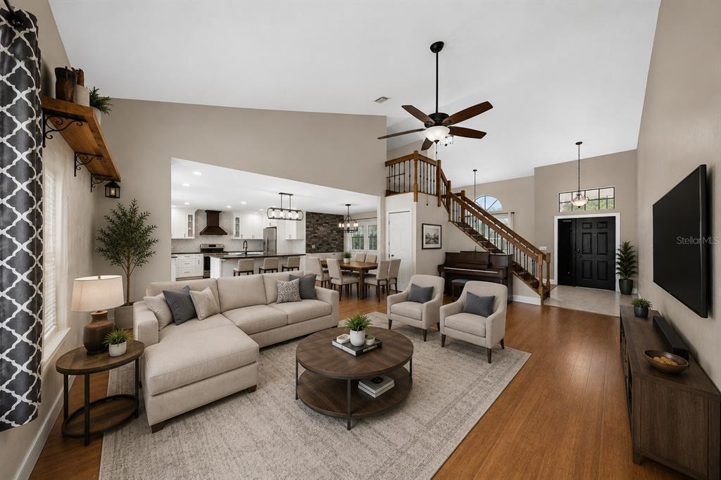 An entryway with tile flooring transitions to wood floors in a room with vaulted ceilings — 1714 CYPRESS RIDGE DRIVE, ORLANDO, FL