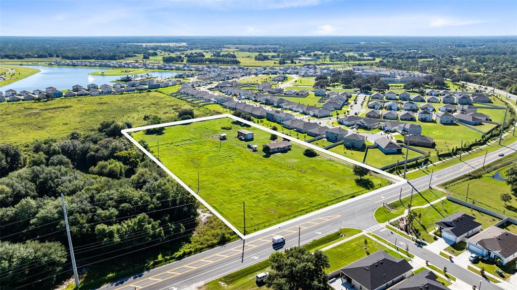 An aerial view shows a large, rectangular vacant lot bordered by a road and houses — 4125 HICKORY TREE ROAD, ST CLOUD, FL