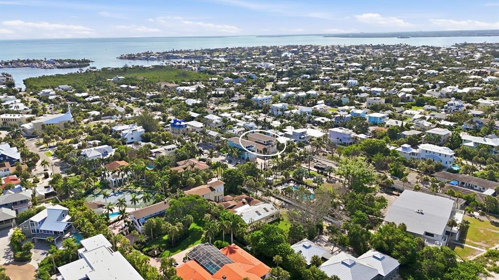An aerial view shows a coastal neighborhood with a circled multi-story house — 113 AQUA LANE, HOLMES BEACH, FL