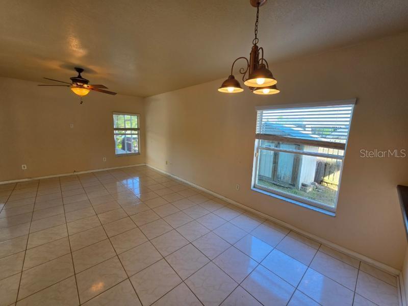 An empty room with light-colored tile flooring, a ceiling fan, and a hanging light fixture — 731 CRISTELLE JEAN DRIVE, RUSKIN, FL
