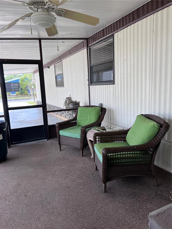 A screened-in porch features two wicker chairs with green cushions and a ceiling fan — 3326 DENISE DRIVE, ELLENTON, FL