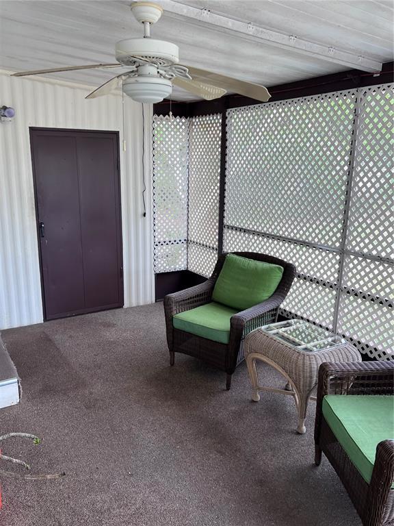A covered porch features a ceiling fan, lattice walls, and two wicker chairs with cushions — 3326 DENISE DRIVE, ELLENTON, FL