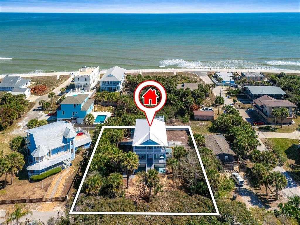 An aerial view shows a beach house with a white roof surrounded by palm trees — 9106 MELLON COURT, ST AUGUSTINE, FL