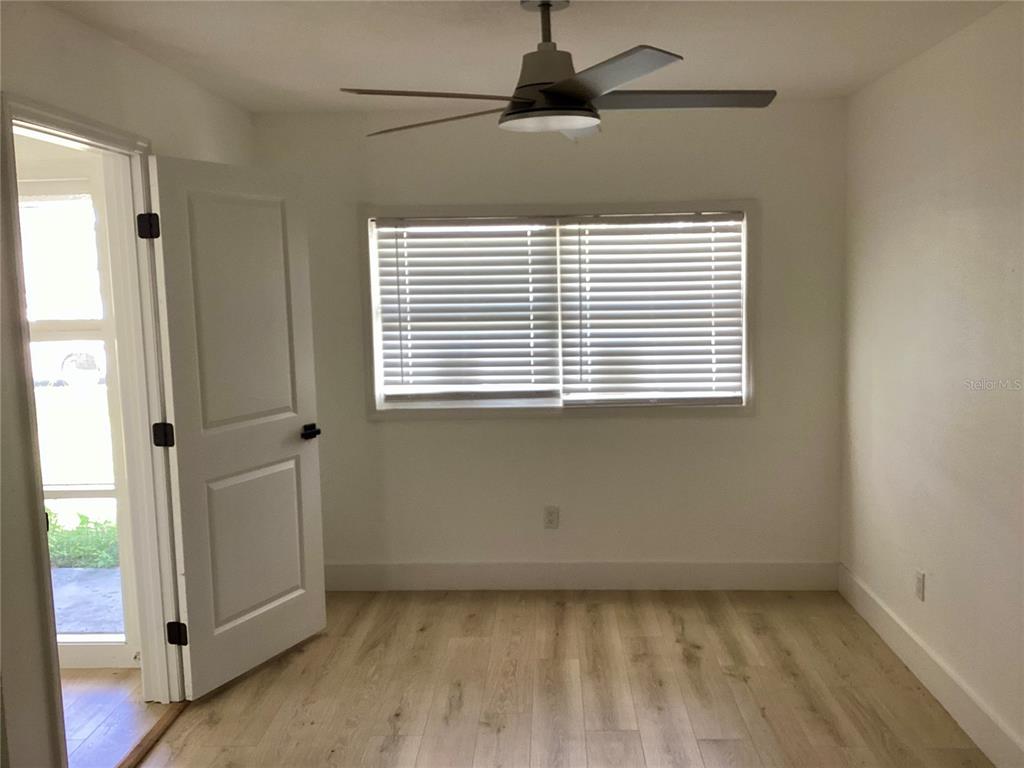 A bedroom with light wood-look flooring, a ceiling fan, and a window with white blinds — 2370 BAHIA VISTA STREET, SARASOTA, FL