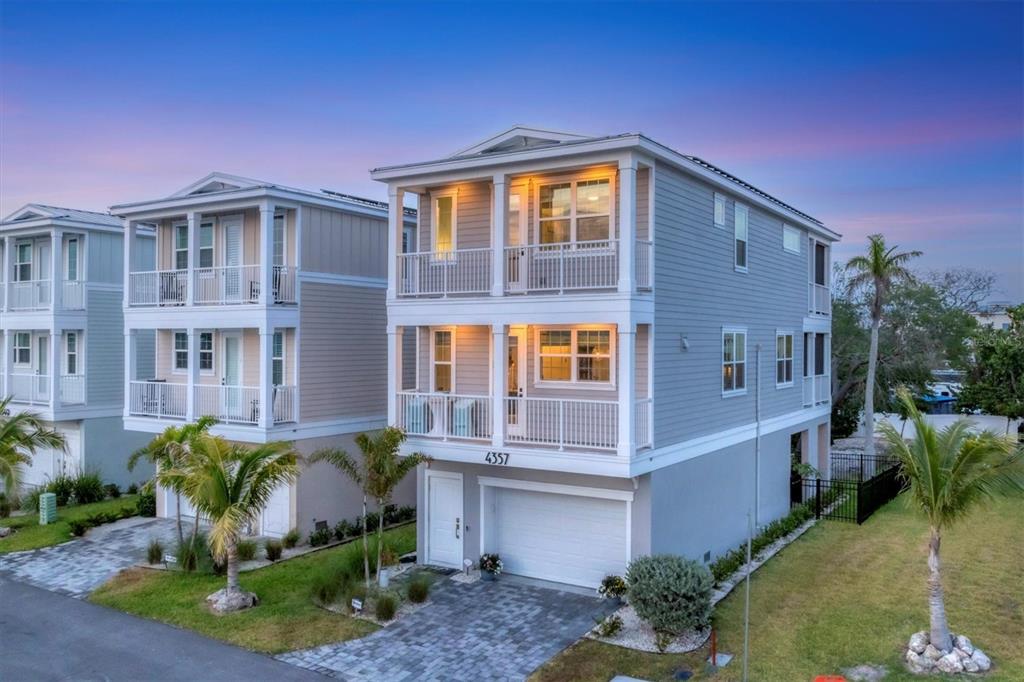 A two-story house with light gray siding, white trim, and a two-car garage — 4357 MARINA VIEW WAY, CORTEZ, FL