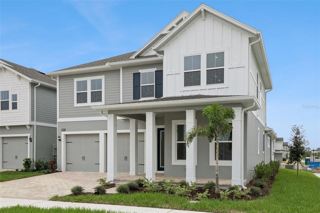 An entryway features a staircase with black treads, white walls, and a light wood floor — 17434 HONEYBELL TANGELO COURT, WINTER GARDEN, FL