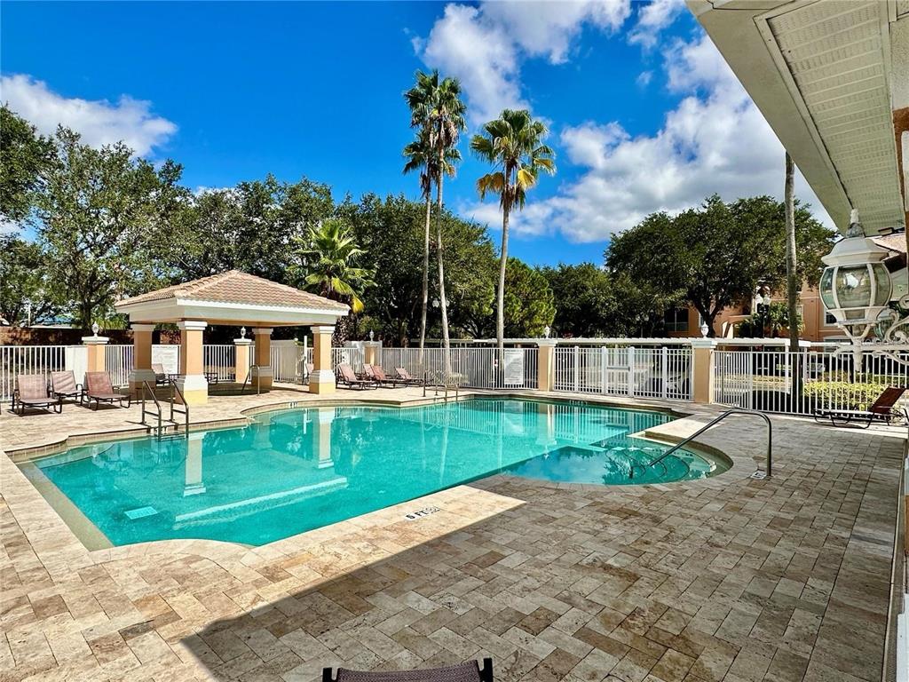 A swimming pool with a gazebo and palm trees on a paved patio area — 13536 TURTLE MARSH LOOP UNIT 532, ORLANDO, FL