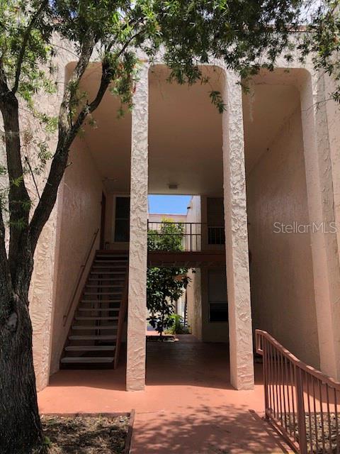 An exterior view of a multi-story apartment building with an open breezeway and metal stairs — 548 ORANGE DRIVE UNIT 14, ALTAMONTE SPRINGS, FL