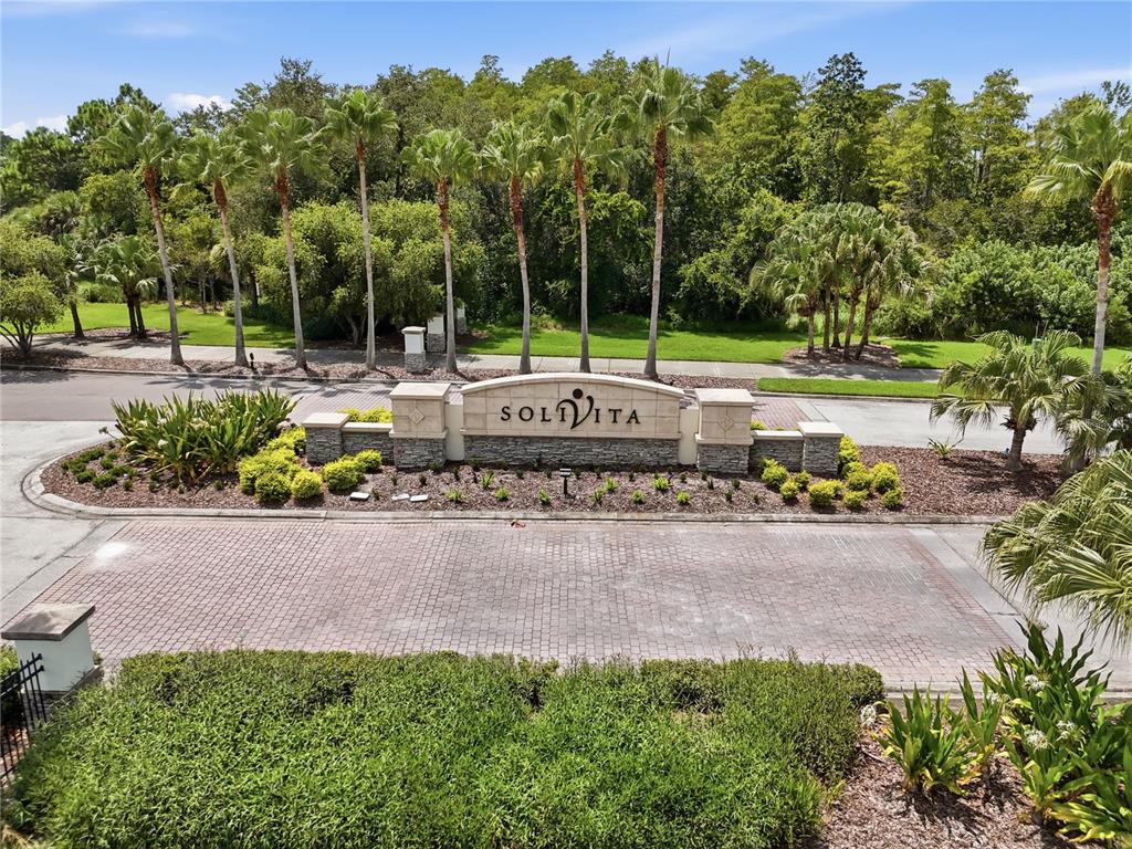 A stone monument sign for Solivita stands in front of palm trees and a paved driveway — 513 BARCELONA DRIVE, KISSIMMEE, FL