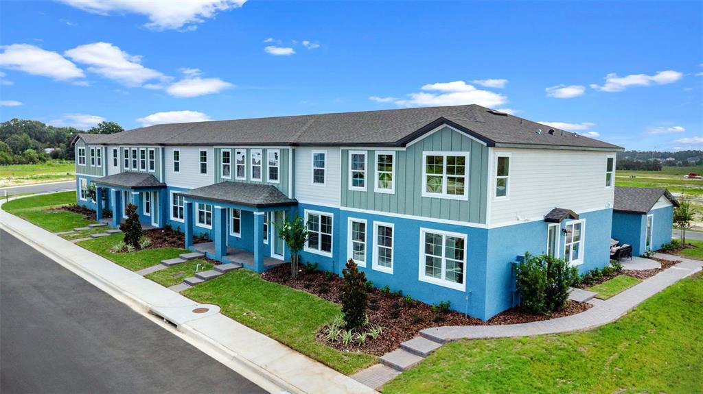 An exterior view of a two-story blue and green multi-family residential building — 743 BLISSFUL GARDENS WAY, APOPKA, FL