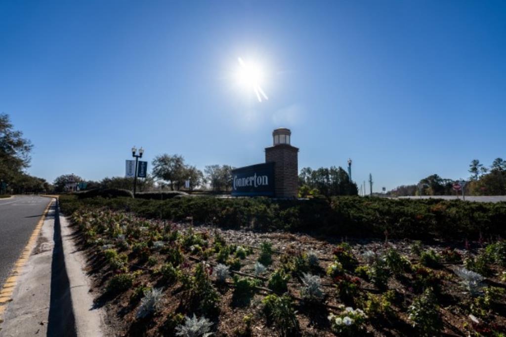 A brick monument sign for Connerton stands in a landscaped garden under a bright sun — 8355 SWISS CHARD CIRCLE, LAND O LAKES, FL
