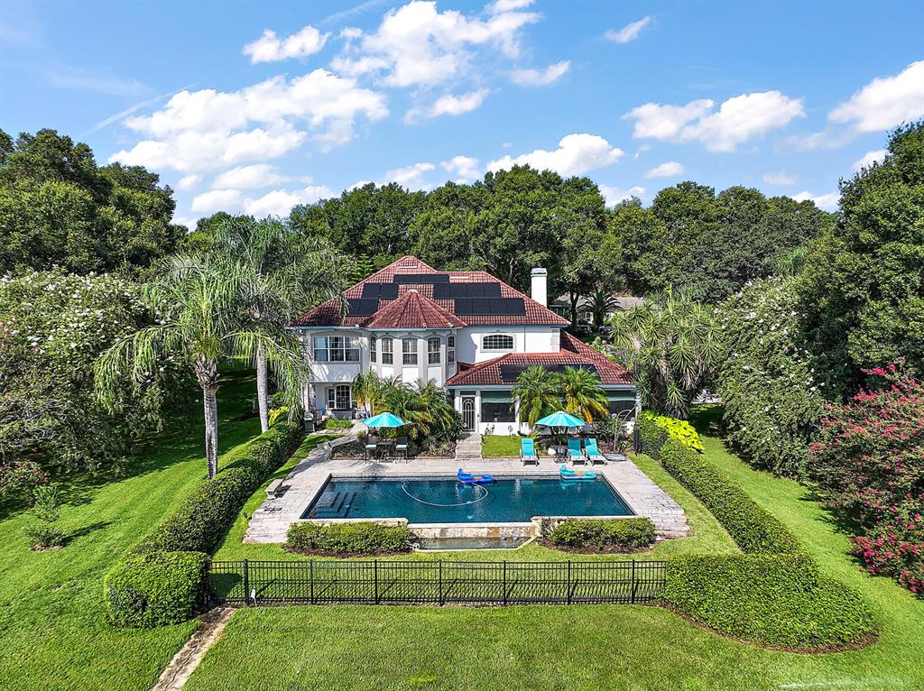 An aerial view of a two-story house with a swimming pool and solar panels — 2701 REGAL POINT PLACE, EUSTIS, FL