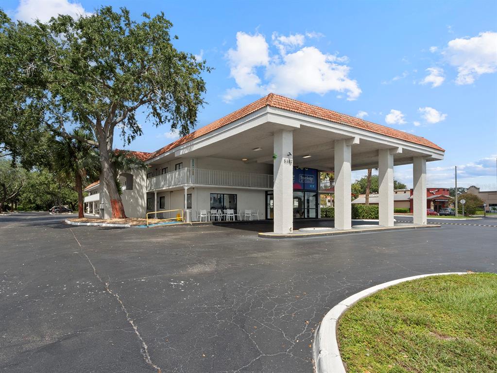 A low-rise hotel building features a large covered entrance with white pillars and a parking lot — 5367 W IRLO BRONSON MEMORIAL HIGHWAY UNIT 1-120, KISSIMMEE, FL