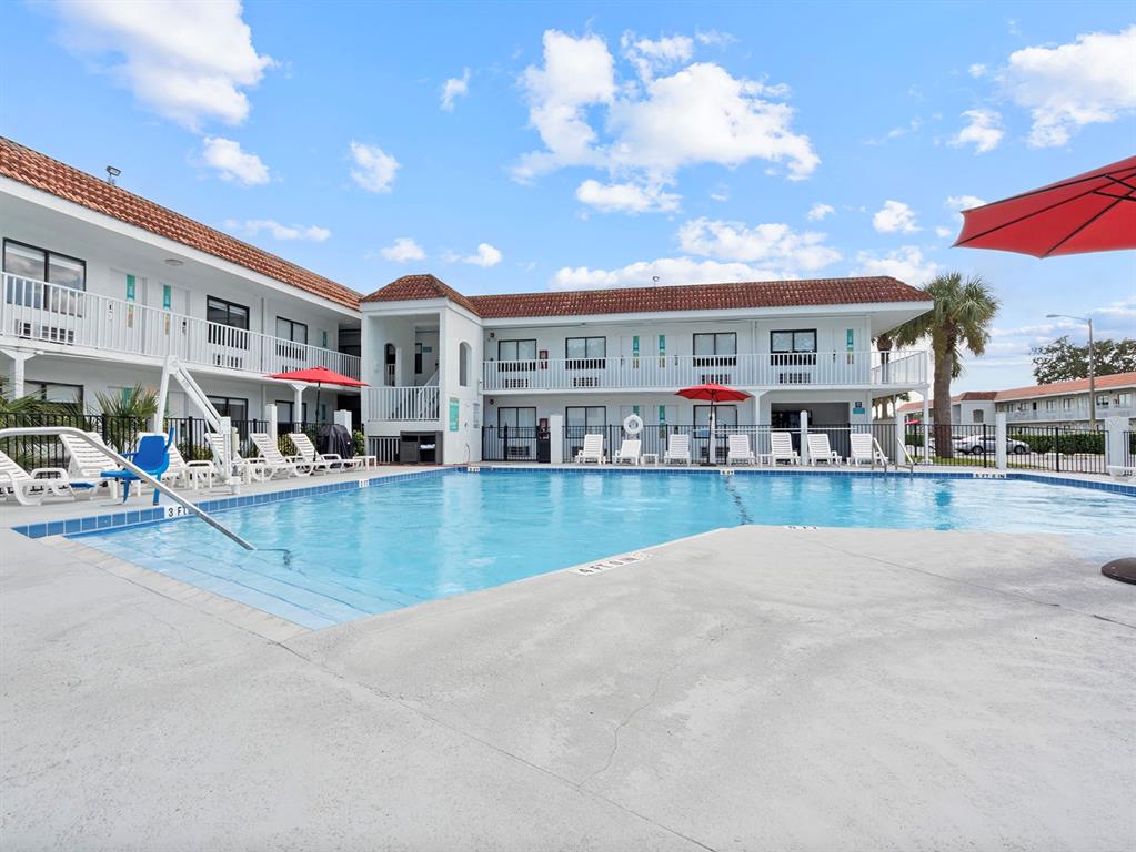 A swimming pool sits in front of a two-story hotel building with white balconies — 5367 W IRLO BRONSON MEMORIAL HIGHWAY UNIT 1-120, KISSIMMEE, FL